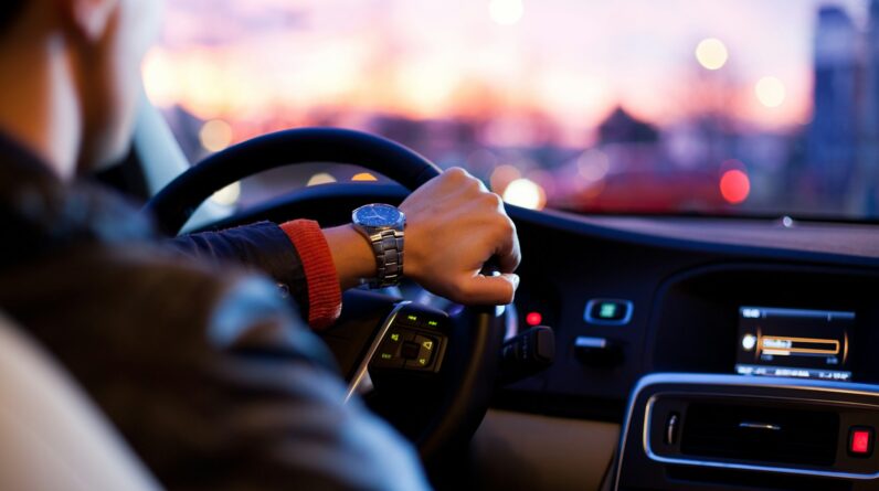 man driving a car wearing wrist watch