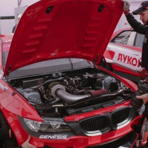 a group of men working on a red car