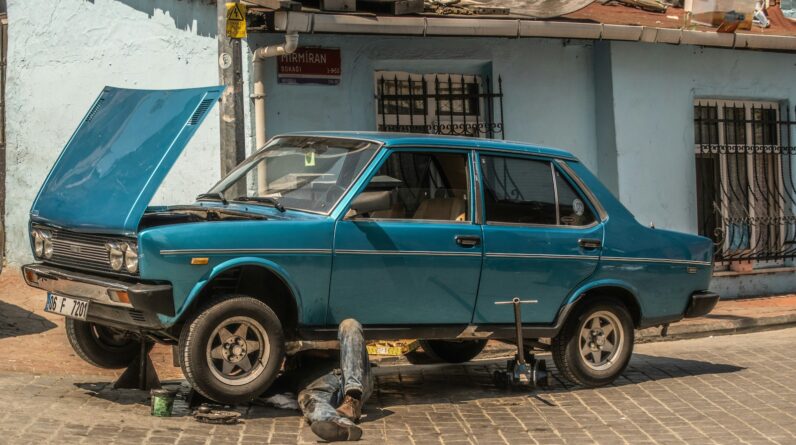 a blue car parked in front of a blue building